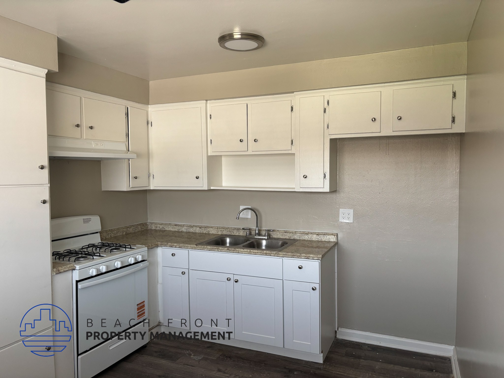 , A kitchen with white cabinets and a stove top oven.,A kitchen with white cabinets and a stove top oven.